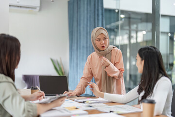 Women collaborating on project ideas in a modern office meeting.