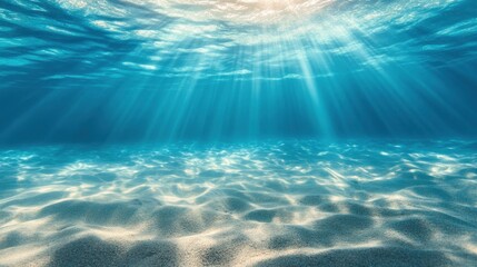 A tranquil underwater scene capturing sunlight filtering through calm ocean waters, illuminating the sandy seabed.