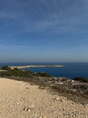 The vast sea, a boat in the distance, a rocky shore.