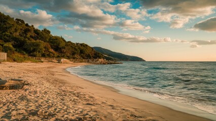 Serene sandy beach with gentle waves at sunset golden hues reflecting on calm water surrounded by lush green hills and distant mountains