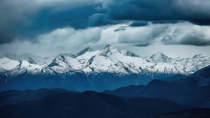 Majestic snowcapped mountains loom under dark stormy clouds with dramatic lighting showcasing the rugged terrain of a powerful nature landscape
