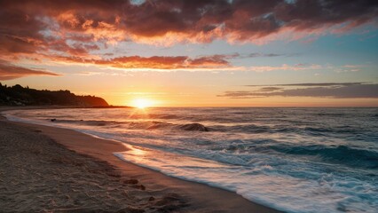 Obraz premium Tranquil beach at sunrise with vibrant orange and pink clouds reflecting over an endless blue sea, gentle waves lapping on golden sand shore.