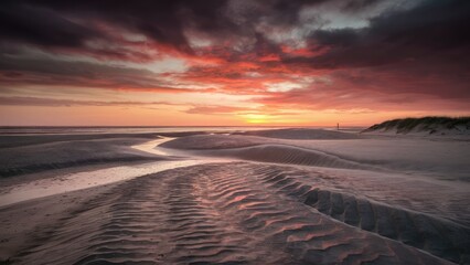 Vibrant sunset over a serene beach with rippled sand patterns and dramatic clouds in shades of orange and purple reflecting on wet sand.