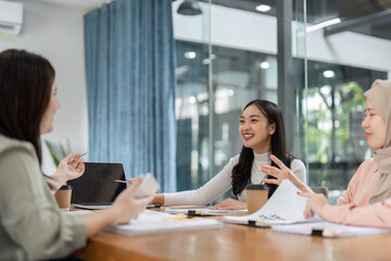 Engaged female professionals presenting financial reports in a collaborative office environment.