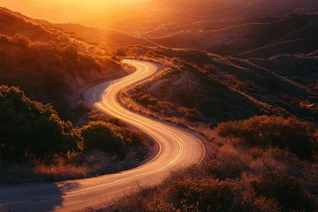 Fototapete Rund Winding Road Through Golden Hills At Sunset With Orange Glow And Mountain Landscape In Background © Kiss
