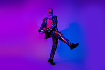 Obraz premium Full length photo of cheerful positive guy dressed shiny costume star eyeglasses enjoy glamour event emtpy space isolated purple color background
