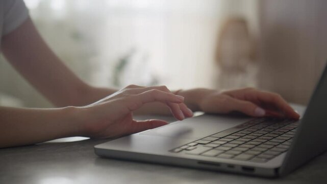 Close-up of hands scrolling on a laptop touchpad