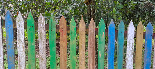 Multi Colored Wooden Fence with blur background in the garden. copy space. selective focus	
