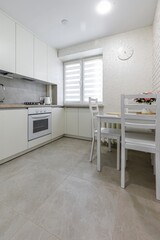 Modern Kitchen with White Furniture and Dining Area