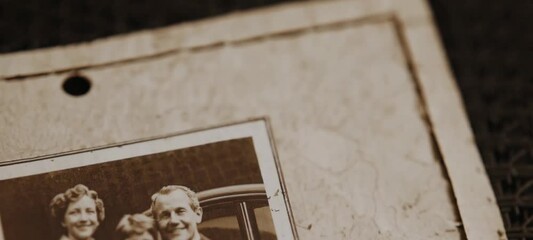 Nostalgic family portraits being flipped through in vintage photo album - Powered by Adobe