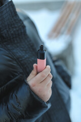 an eleven year old child tries a nicotine-free disposable cigarette on a city street
