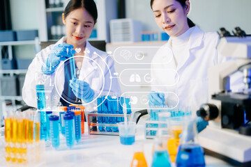 Two Asian female scientists conduct biochemical research using micro pipettes in a high-tech...