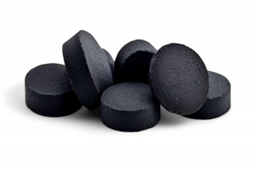 Black charcoal tablets pile on transparent background health alternative