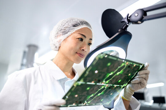 Engineer expert working in advanced technology factory and controlling quality of printed circuit board for electronics industry.