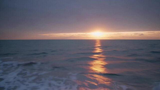 A long exposure wide shot blurs the waves into misty streaks as the sun peeks over the horizon, casting a golden glow.

