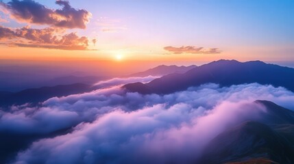 Fototapeta premium sunset, with clouds below, glowing in soft pinks and purples. The distant peaks emerge from the mist, bathed in golden twilight.