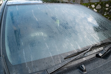 A car window covered in mist, with condensation forming a foggy pattern, set in an outdoor...