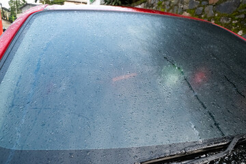 A window covered in mist, with condensation forming a foggy pattern and a reddish hue from the outdoor environment