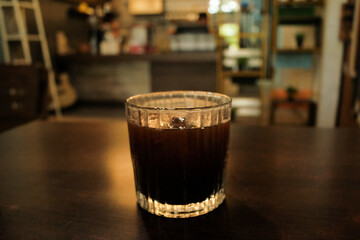 A cup of Americano placed on a table in a cozy café, with a simple and inviting ambiance perfect for relaxing or working
