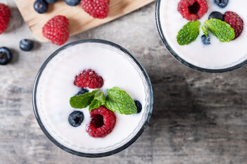 Fresh raspberry and blueberry smoothie on wooden table. Top view