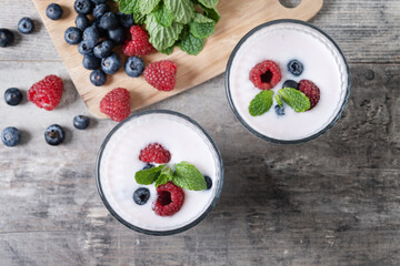 Fresh raspberry and blueberry smoothie on wooden table. Top view