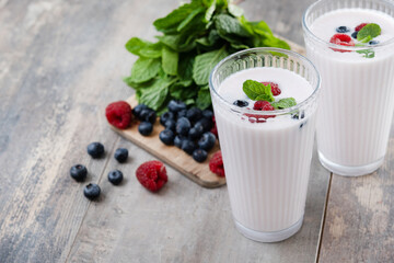 Fresh raspberry and blueberry smoothie on wooden table. Copy space