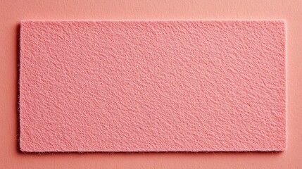 Fototapeta premium A soft, textured pink mat laid against a complementary background, showcasing its plush surface and simple rectangular design.