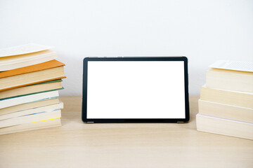 Digital tablet with empty white display on wooden table