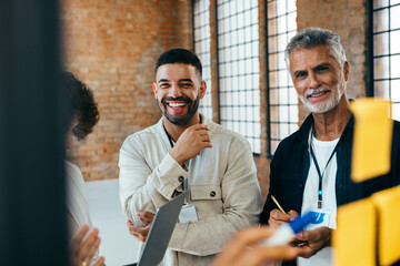 Smiling male colleagues engaged in a successful team brainstorming session