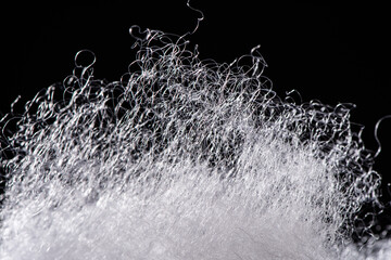 closeup of polyester stable fiber on black background. synthetic fibre