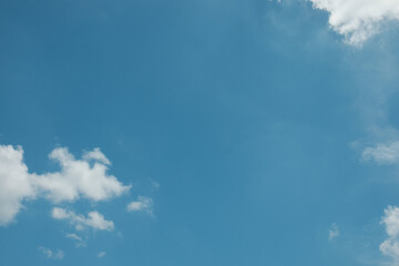 A simple, minimalistic scene of a lone white cloud floating in a vast blue sky, creating a clean and serene atmosphere