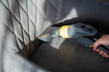 Services for washing and cleaning upholstered furniture with a vacuum cleaner. Cleaning dirty gray...