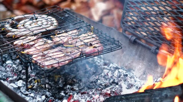 Grilling mutton chops and traditional South African sausage on hot coals of fire