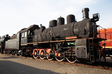 Black old steam locomotive at a museum exhibition, industry