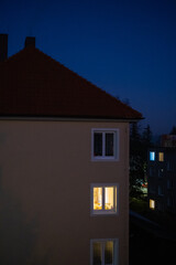 Warm apartment window lights in dark residential area