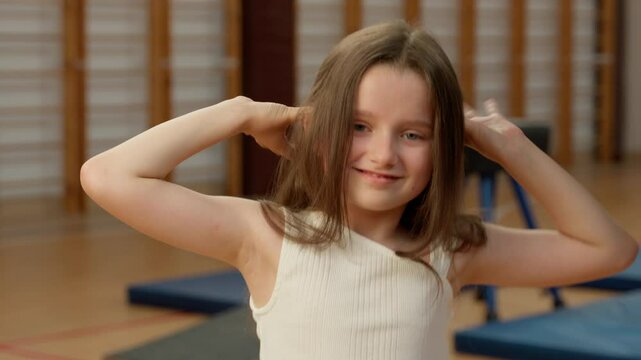 Little Caucasian girl grimacing fooling childhood childish expression emotions game playful daughter child schoolgirl kid pupil school fun hands gesture face learner gym sport student education lesson