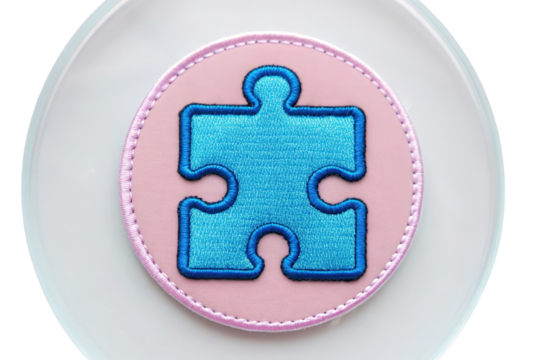 Colorful Embroidered Patch with Puzzle Piece Design on Soft Circular Background