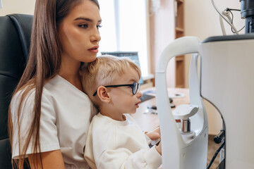 In the ophthalmologist cabinet. Little boy is having check up