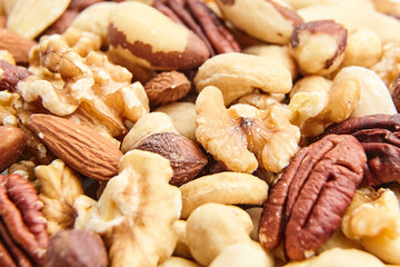 A detailed close-up of mixed nuts, including walnuts, pecans, cashews, almonds, Brazil nuts, and hazelnuts, highlighting natural textures and tones