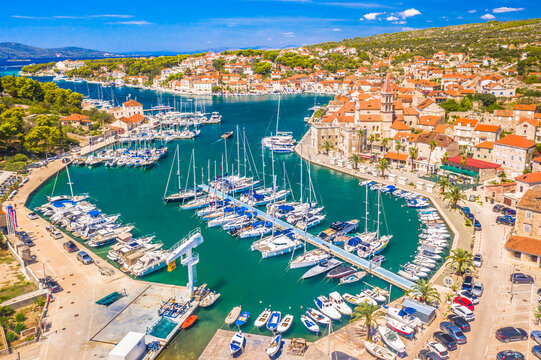 A stunning view of the deep marina in Milna on Brac Island, Croatia, showcasing its crystal-clear Adriatic waters, moored yachts, and charming waterfront, bathed in warm Mediterranean sunlight
