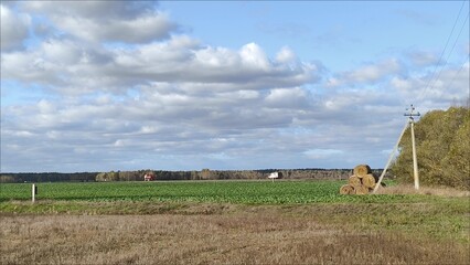 An agricultural landscape, a farmer's field, agricultural machinery passing along the highway. Farm...