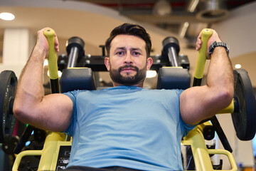 Man strength training on gym equipment for fitness