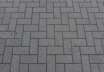 Texture of square paving tile. Pattern of gray sidewalk tiles in the street. Concrete pavers close up background.	