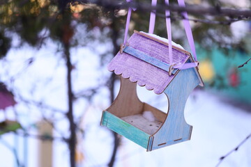 A bird feeder hangs from a tree branch, providing sustenance for backyard birds.