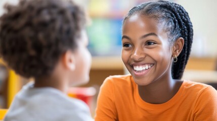 Fototapeta premium Young female teacher smiling at child in classroom setting