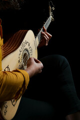 Woman playing the baroque guitar, no faces shown
