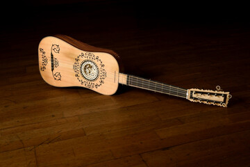 View of a baroque guitar isolated on a wooden background