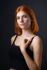 Fototapeta premium Cute red-haired girl, studio portrait on a black background.