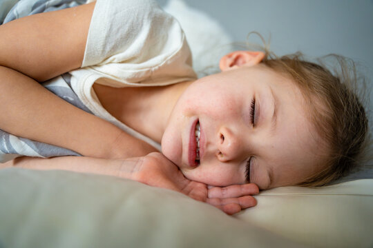 Cute little girl sleeping and grinding teeth in dreams, clenched teeth with tiredness and stress 