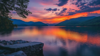 Fototapeta premium Vibrant sunset over serene lake with reflective waters and majestic mountains